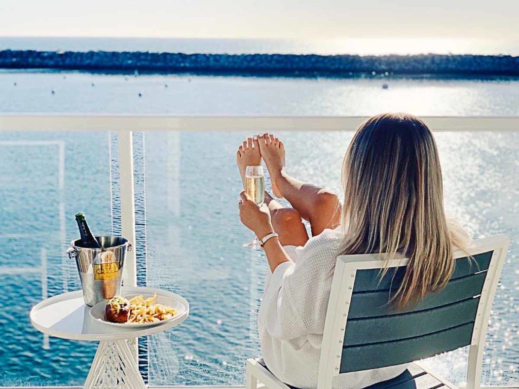 Girl drinking champagne on the balcony.