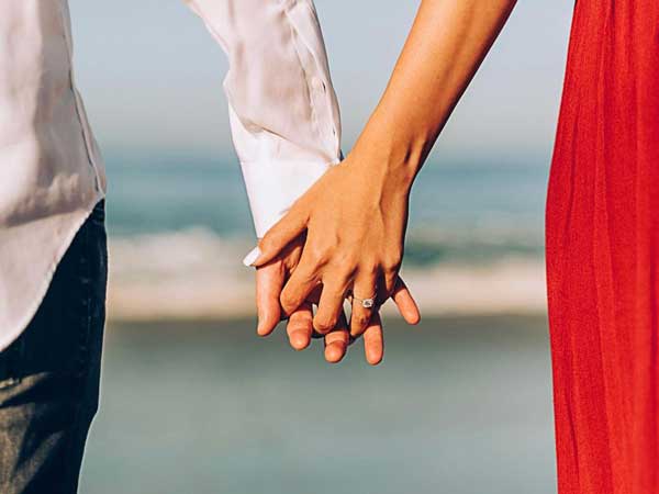 Holding Hands On The Beach.