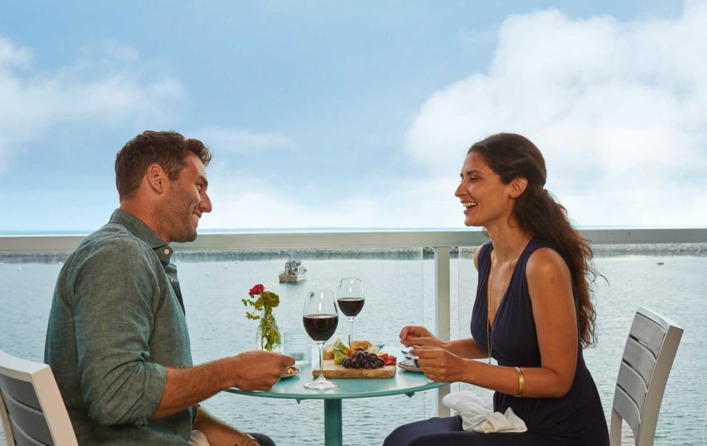 Couple Having Dinner And Wine On The Balcony.