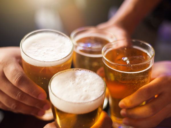 4 people cheering with beers