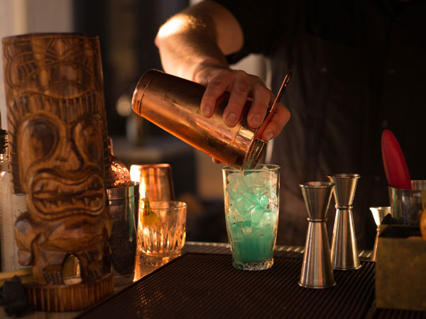 bartender pouring cocktail at Purple Orchid bar