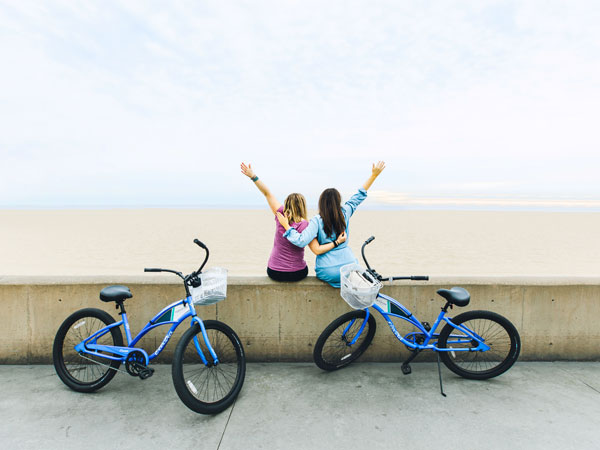 2 girls with bikes in front of beach