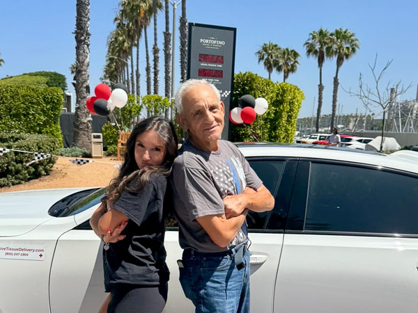 Two People In Front Of A Car