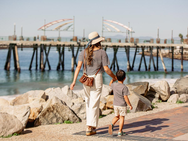 Mother And Son Walking By The Ocean